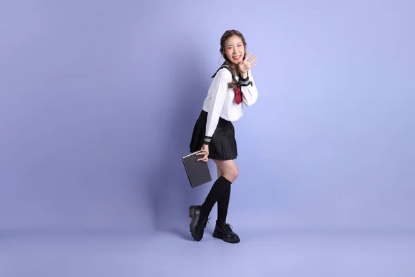 Mor Arka Planda Duran Japon Öğrenci Üniformalı Asyalı Kız — Stok fotoğraf