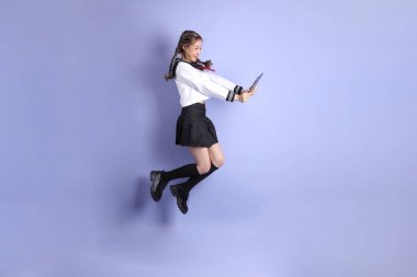 Mor arka planda duran Japon öğrenci üniformalı Asyalı kız..