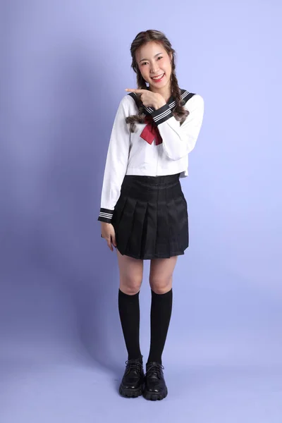 Azjatka Japońskim Uniformie Studenckiej Stoi Fioletowym Tle — Zdjęcie stockowe