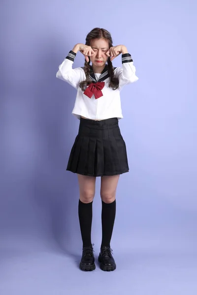 Ασιάτισσα Την Ιαπωνική Φοιτητική Στολή Που Στέκεται Στο Μωβ Φόντο — Φωτογραφία Αρχείου