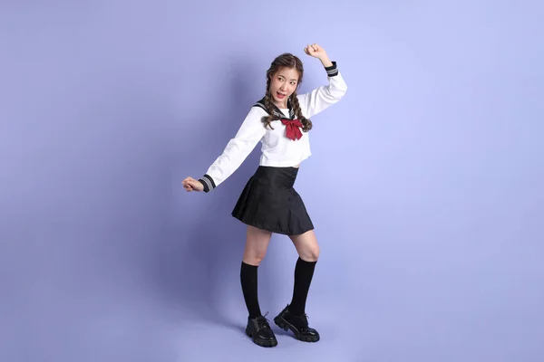 Das Asiatische Mädchen Japanischer Studentenuniform Steht Auf Dem Lila Hintergrund — Stockfoto