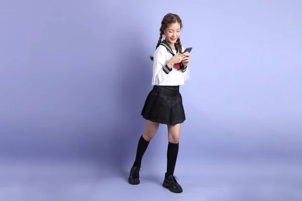 Азіатська Дівчина Японській Студентській Формі Стоїть Фіолетовому Фоні — стокове фото
