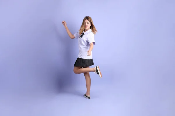 Das Asiatische Mädchen Thailändischer Studentenuniform Steht Auf Dem Lila Hintergrund — Stockfoto