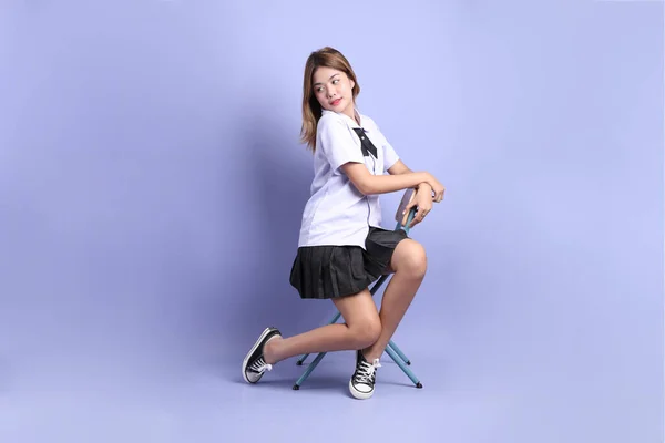 Азіатська Дівчина Тайській Студентській Формі Сидить Стілець Фіолетовому Фоні — стокове фото