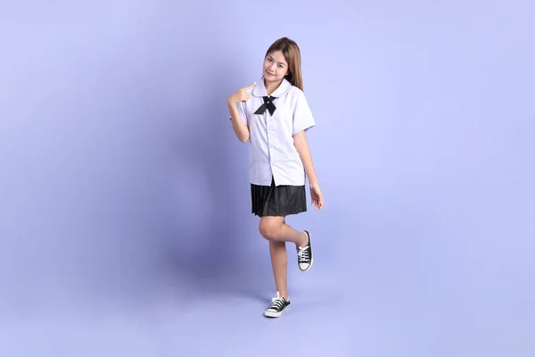 Das Asiatische Mädchen Thailändischer Studentenuniform Steht Auf Dem Lila Hintergrund — Stockfoto