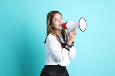 Yeşil arka planda duran Japon öğrenci üniformalı Asyalı kız..