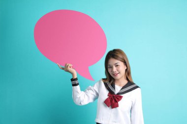 Yeşil arka planda duran Japon öğrenci üniformalı Asyalı kız..