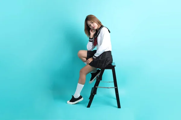 Asijky Dívka Japonské Studentské Uniformě Sedí Židli Zeleném Pozadí — Stock fotografie