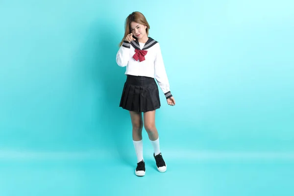 緑の背景に立っている日本の学生制服のアジアの少女 — ストック写真