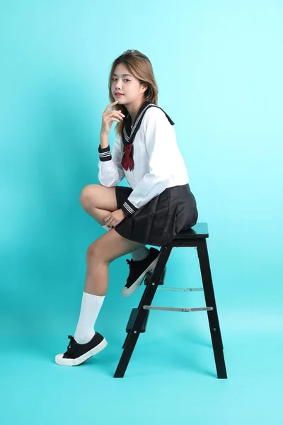 Азіатська Дівчина Японській Студентській Формі Сидить Стільці Зеленому Фоні — стокове фото