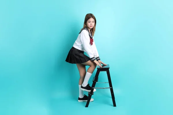 Japon Öğrenci Üniformalı Asyalı Kız Yeşil Arka Planda Sandalyede Oturuyor — Stok fotoğraf