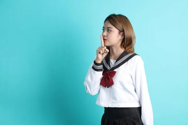 緑の背景に立っている日本の学生制服のアジアの少女 — ストック写真