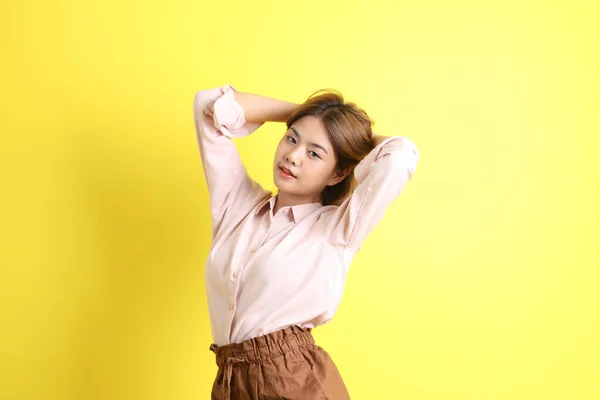 Die Asiatin Legerer Kleidung Steht Auf Gelbem Hintergrund — Stockfoto