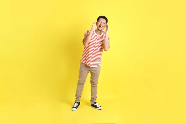 Sarı Arka Planda Dikilen Sıradan Giysili Yetişkin Asyalı Adam — Stok fotoğraf