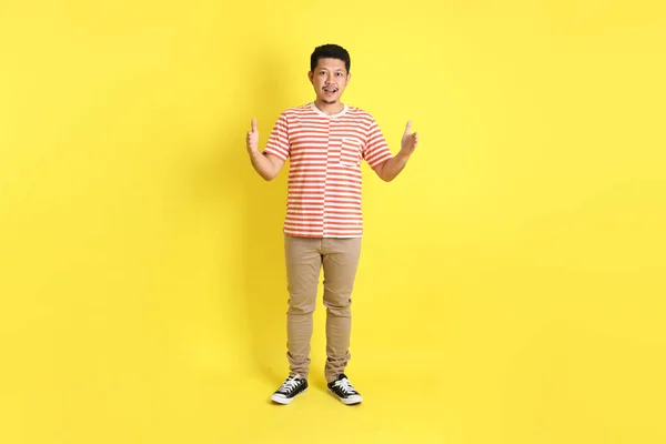 Sarı Arka Planda Dikilen Sıradan Giysili Yetişkin Asyalı Adam — Stok fotoğraf