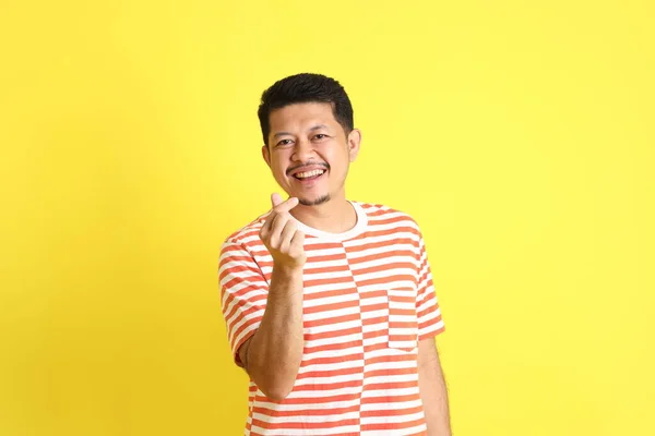 黄色の背景に立っているカジュアルな服の大人のアジア人男性 — ストック写真