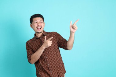 Yeşil arka planda duran şık giysili Asyalı yetişkin adam..