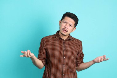 Yeşil arka planda duran şık giysili Asyalı yetişkin adam..