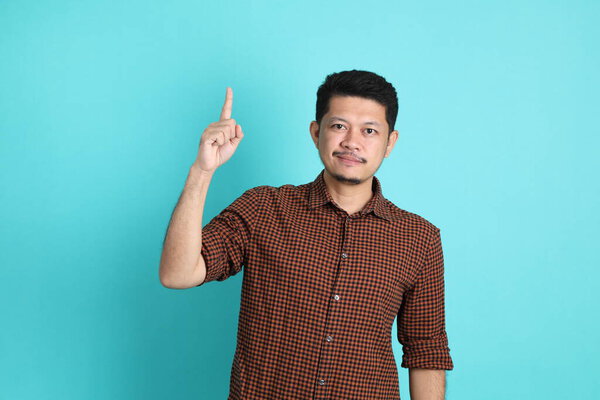 The adult Asian man in smart casual clothes standing on the green background background.