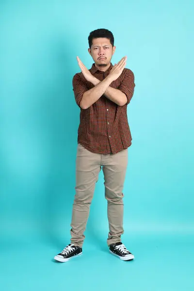 緑の背景に立っているスマートなカジュアルな服の大人アジア人男性 — ストック写真