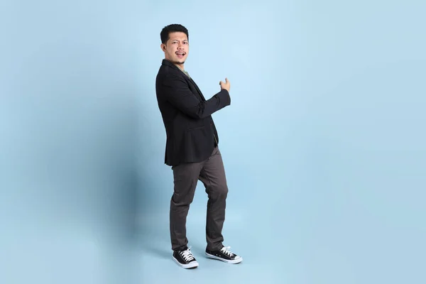 緑の背景に立っているスマートなカジュアルな服のアジアの大人のビジネスマン — ストック写真