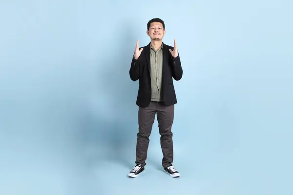 stock image The adult business Asian man in smart casual clothes standing on the green background background.