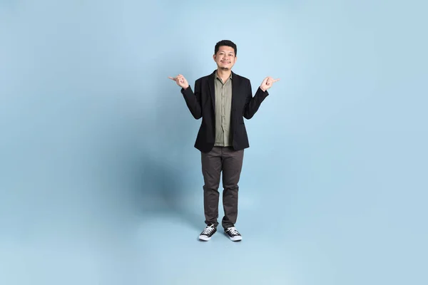 stock image The adult business Asian man in smart casual clothes standing on the green background background.