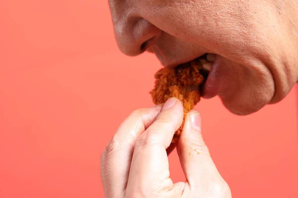 Ασιάτης Τρώει Τηγανητό Κοτόπουλο Στο Πορτοκαλί Φόντο — Φωτογραφία Αρχείου