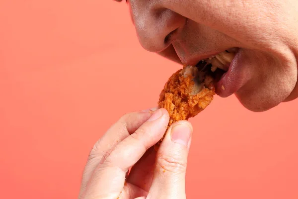 Den Asiatiske Mannen Spiser Dyp Stekt Kylling Den Oransje Bakgrunnen – stockfoto