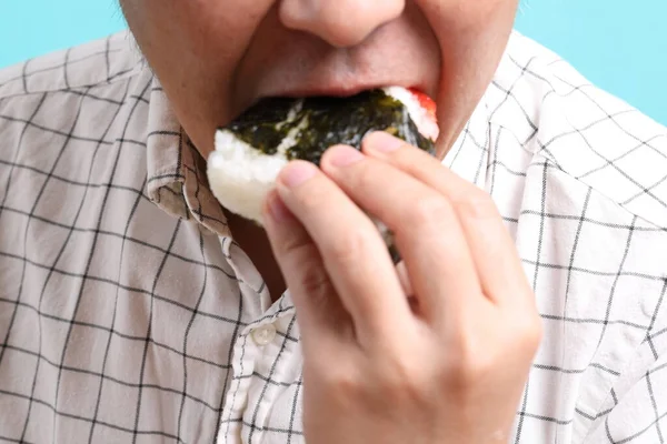 Uomo Asiatico Mangia Onigiri Sullo Sfondo Verde — Foto Stock