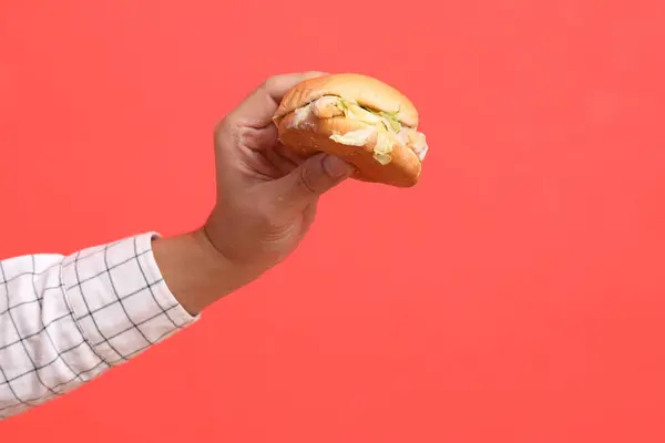 Tangan Pria Asia Memegang Hamburger Latar Belakang Oranye — Stok Foto