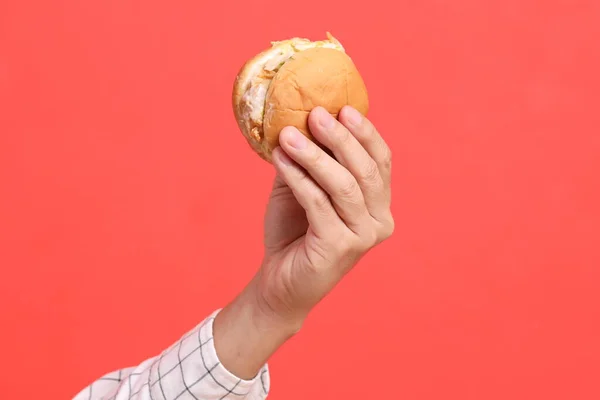 Uomo Asiatico Mano Che Tiene Hamburger Sullo Sfondo Arancione — Foto Stock