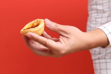 Turuncu arka planda yumurtalı tart tutan Asyalı adam..