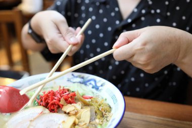 Restoranda ramen yiyen Asyalı kadın..