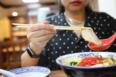 Restoranda ramen yiyen Asyalı kadın..