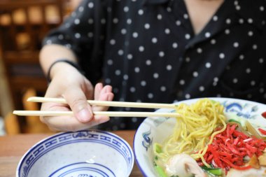 Restoranda ramen yiyen Asyalı kadın..