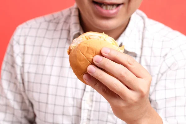 Hombre Asiático Comiendo Hamburguesa Fondo Naranja — Foto de Stock