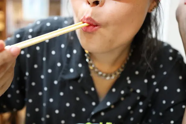 在餐馆里吃日本肉丸子的亚洲女人 — 图库照片