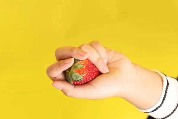 Die Asiatin Hält Erdbeere Der Hand Auf Gelbem Hintergrund — Stockfoto
