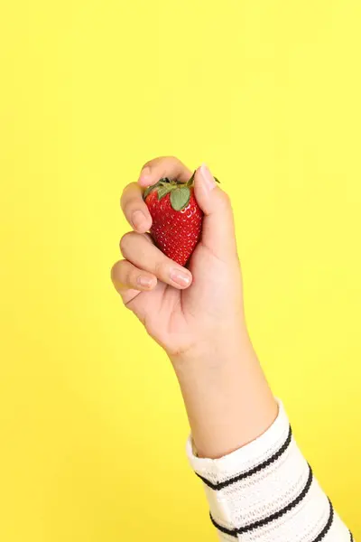 Die Asiatin Hält Erdbeere Der Hand Auf Gelbem Hintergrund — Stockfoto