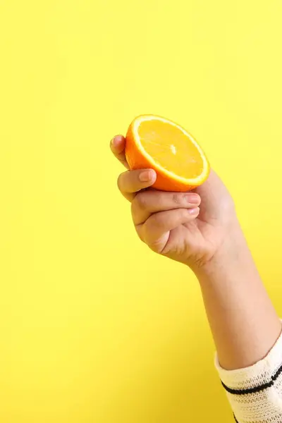 Die Asiatin Mit Orange Der Hand Auf Gelbem Hintergrund — Stockfoto