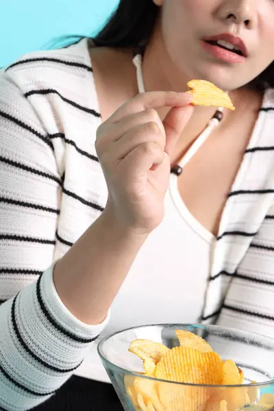Aziatische Vrouw Eten Aardappel Chips Uit Hand Gele Achtergrond — Stockfoto