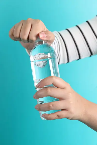 The Asian woman open the cap of the bottle
