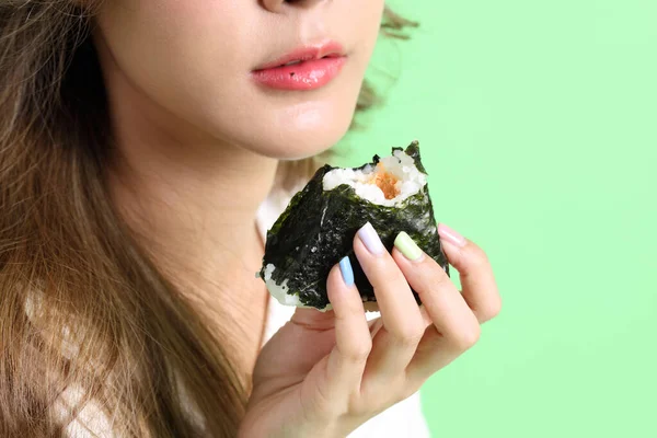 Азиатка Ест Онигири Японскую Еду Руке Зеленом Фоне — стоковое фото