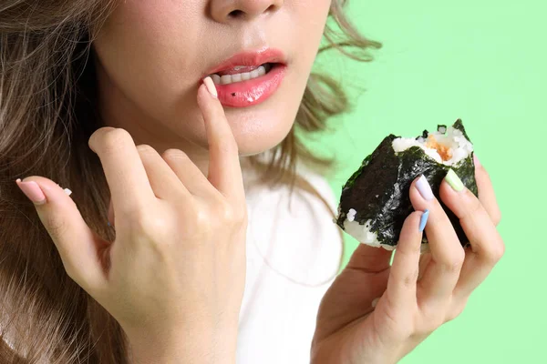 Aziatische Vrouw Eten Onigiri Japans Eten Hand Groene Achtergrond — Stockfoto