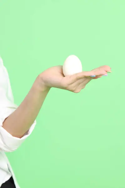 Ασιάτισσα Που Κρατάει Αυγό Στο Χέρι Στο Πράσινο Φόντο — Φωτογραφία Αρχείου