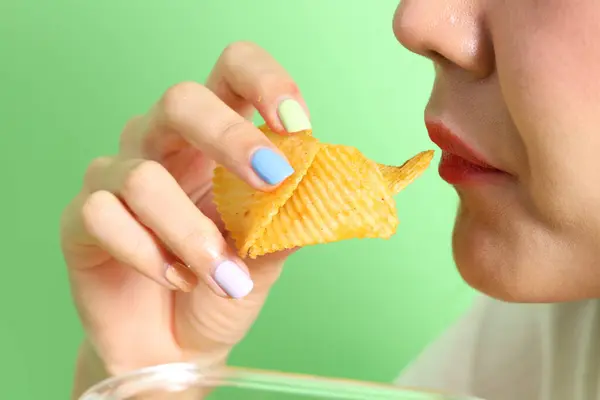 Aziatische Vrouw Eten Aardappel Chips Uit Hand Groene Achtergrond — Stockfoto
