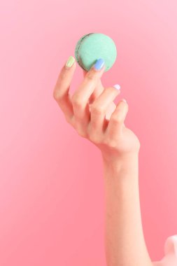 Pembe arka planda elinde kurabiye tutan Asyalı kadın..