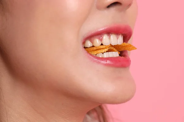 Aziatische Vrouw Eten Aardappel Chips Uit Hand Roze Achtergrond — Stockfoto