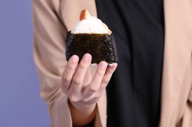 Onigiri 'yi arka planda tutan Asyalı kadın..